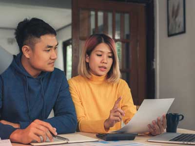 Young couple reviewing bills at table