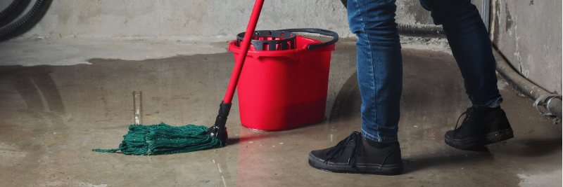 [DECORATION] close-up of person mopping a wet basement floor