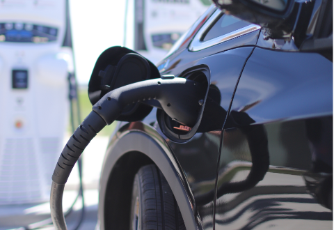 Close-up shot of electric vehicle plugged in at charging station