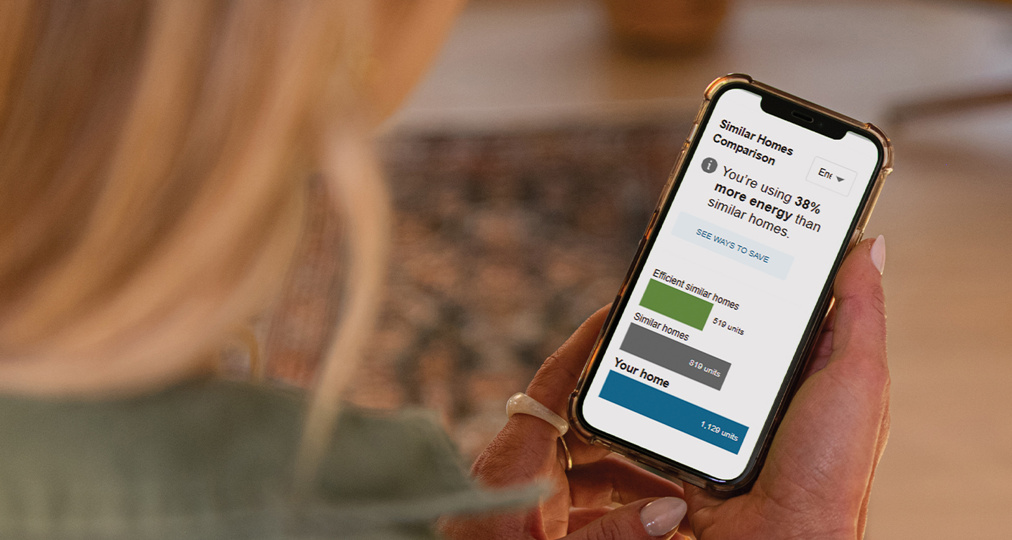 A woman looking at her HomeCheck Online energy assessment via her smartphone