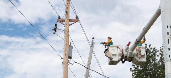 Lineworker in a bucket truck working on an overhead power line