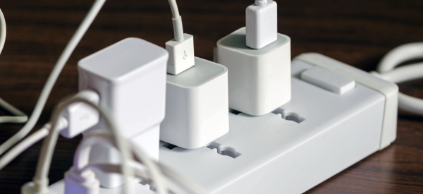 Close-up of a power strip with multiple chargers plugged into the outlets