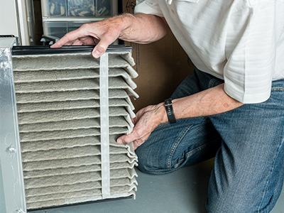 Closeup of a person switching out their furnace filter